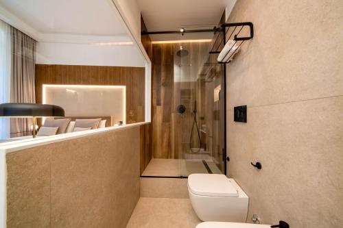 a bathroom with a toilet and a shower at MAMALU - Studios and Suites in Naples