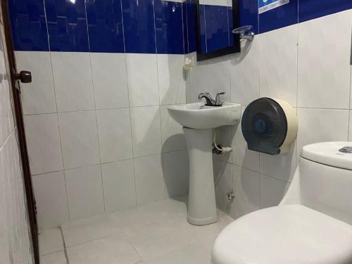 a bathroom with a white toilet and a sink at Hotel Avenida 3 Real en el norte de Cali in Cali