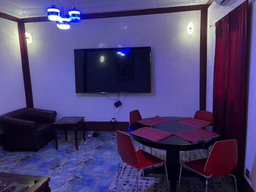 a living room with a table and a flat screen tv at CHEZ NDAYE AMY in Dakar