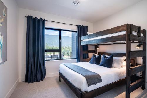 ein Schlafzimmer mit einem Etagenbett und einem großen Fenster in der Unterkunft North Bowl Nook by Revelstoke Vacations in Revelstoke