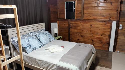 a bedroom with a bed with a tv on the wall at Suíte 77 privativa , há 11km da vila germânica in Blumenau