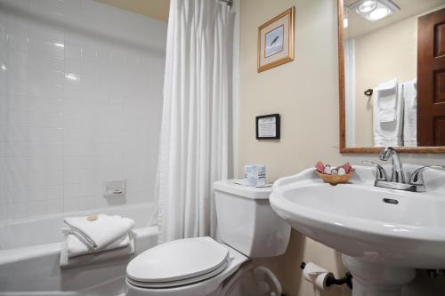 a white bathroom with a toilet and a sink at Weasku Inn in Grants Pass