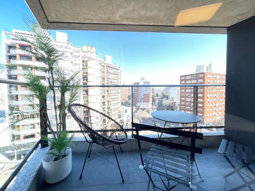 balcón con mesa, sillas y vistas a la ciudad en Moderno apartamento en Punta Carretas en Montevideo