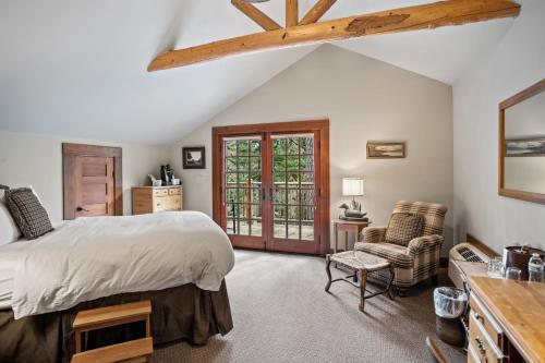 a bedroom with a bed and a chair and a window at Weasku Inn in Grants Pass