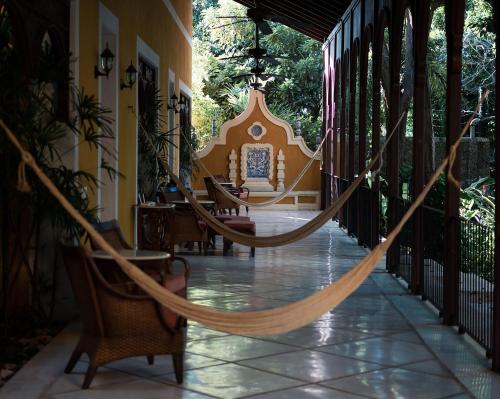 a hammock on the porch of a house at Hacienda San Antonio Millet in Tixkokob