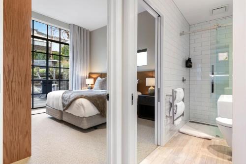 een slaapkamer met een bed en een badkamer bij Lakeside Terrace Luxury by Relaxaway Holiday Homes in Queenstown