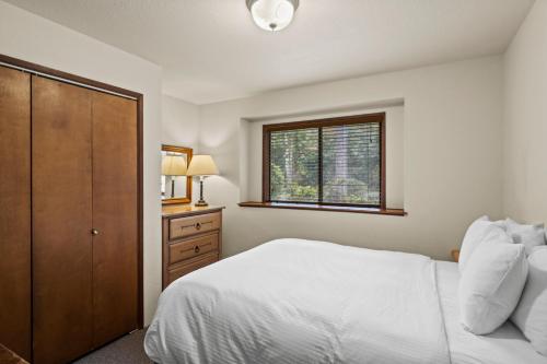 a bedroom with a white bed and a window at Weasku Inn in Grants Pass