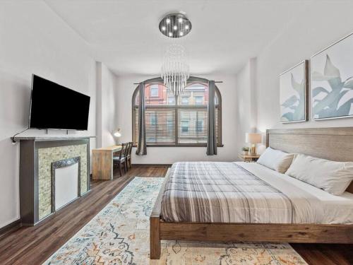 a bedroom with a bed and a tv and a fireplace at Luxury and Stylish 2Bedroom Apartment on Carson, South Flats, Pittsburgh in Pittsburgh