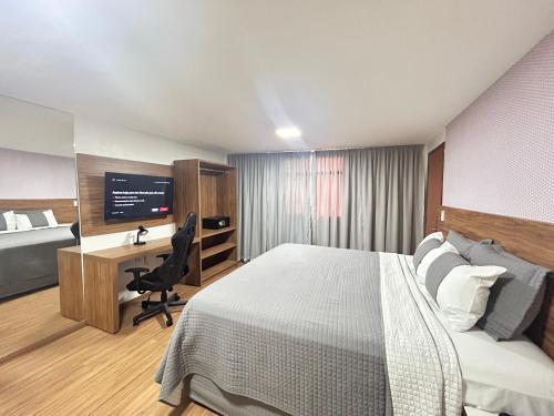 um quarto com uma cama e uma secretária com um computador em Belavista Hotel em Itaberaba