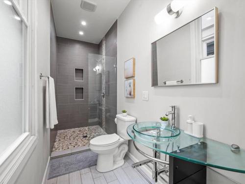 a bathroom with a toilet and a glass sink at Luxury and Stylish 2Bedroom Apartment on Carson, South Flats, Pittsburgh in Pittsburgh