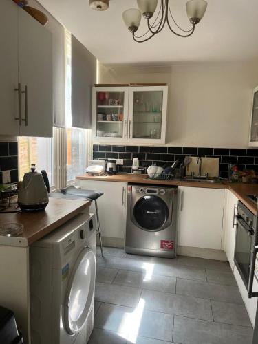 a kitchen with a dishwasher and a washing machine at Home 2 Home in London