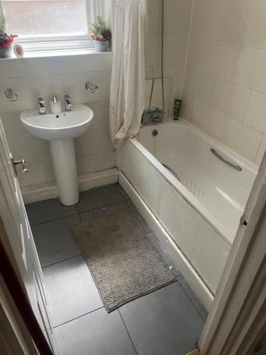 W łazience znajduje się umywalka, wanna, toaleta i umywalka. w obiekcie Home 2 Home w Londynie