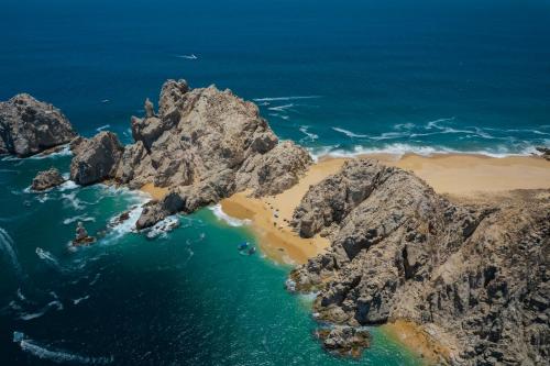 an aerial view of a rocky island in the ocean at ME Cabo by Meliá in Cabo San Lucas
