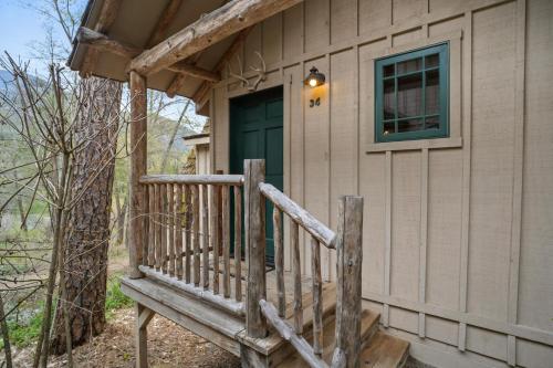 a porch of a cabin with a green door at Weasku Inn in Grants Pass