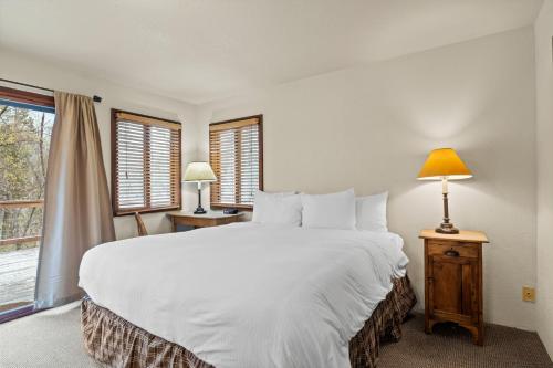 una camera da letto con un grande letto bianco e una finestra di The River House a Rogue River