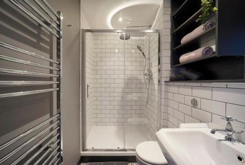 a bathroom with a shower and a toilet and a sink at Stylish & Elegant city centre apartment in Leeds