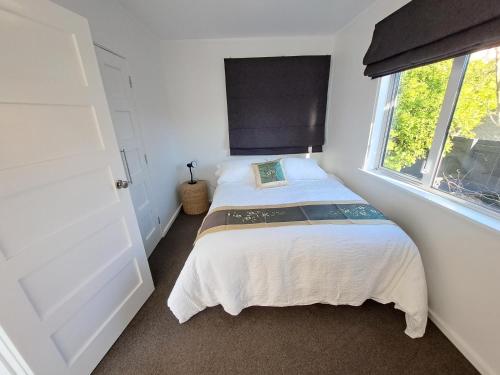 małą sypialnię z łóżkiem z oknem w obiekcie 3bdrm plus Sleepot Home, w mieście Nelson