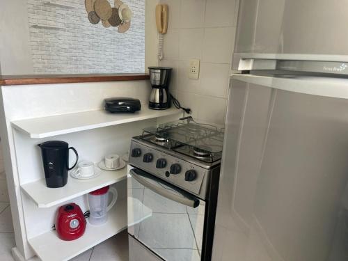 a small kitchen with a stove and a refrigerator at Deslumbrante Vista Mar na Praia de Copacabana in Rio de Janeiro