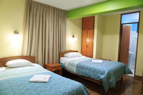 um quarto de hotel com duas camas e uma janela em HOTEL ABANCAY em Abancay