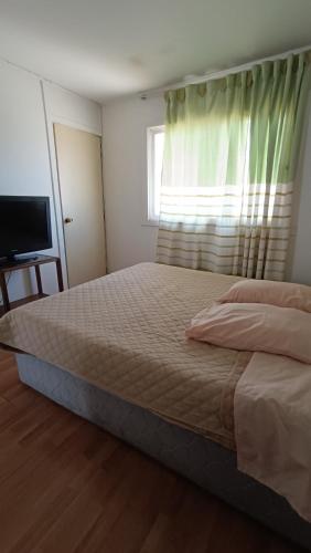 um quarto com uma cama grande e uma janela em Residencial familiar EL Valle em Copiapó