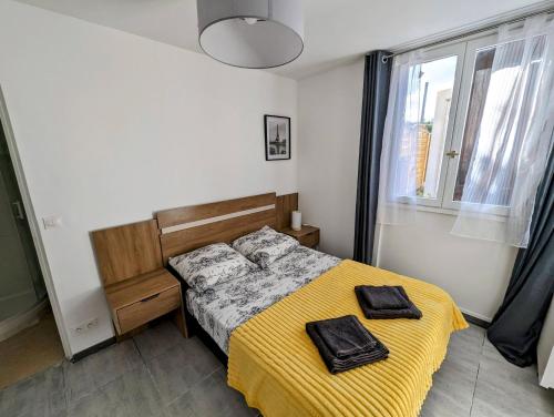 um quarto com uma cama com um cobertor amarelo em Appartements avec terrasse proche métro - Paris à 25min em Créteil