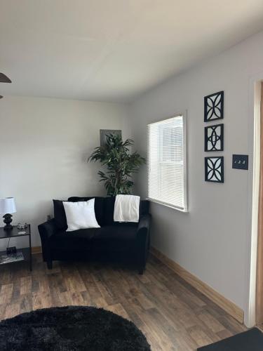 a living room with a black couch and a window at Tiny House in Statesville