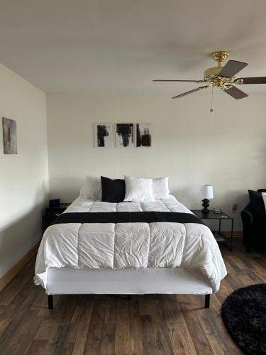 a bedroom with a white bed with a ceiling fan at Tiny House in Statesville