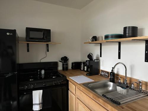 a kitchen with a sink and a stove and a sink at Tiny House in Statesville
