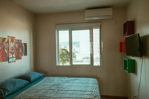 a bedroom with a bed and a window at Cantinho da Ernesto in Santa Maria