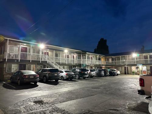 un estacionamiento con autos estacionados frente a un edificio en Royal Victorian Motel en Port Angeles