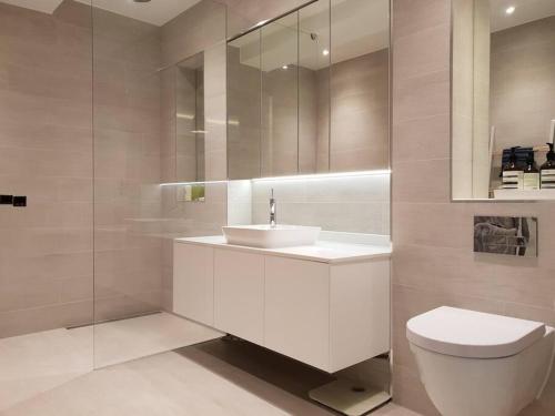 a white bathroom with a sink and a toilet at Luxury 3 Bed Mayfair Apartment in London
