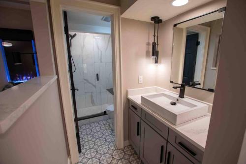 ein Badezimmer mit einem weißen Waschbecken und einer Dusche in der Unterkunft Modern Studio Basement with Private Entrance in Centennial