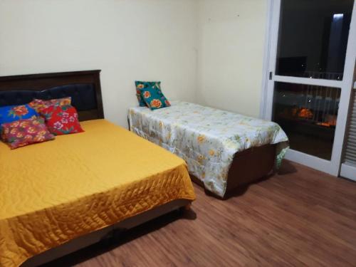 a room with two beds and a window at hospedagens regina in Águas de Lindóia