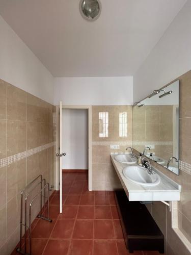 a bathroom with two sinks and a mirror at Apartamentos Sevilla Deluxe Rosales in Los Rosales