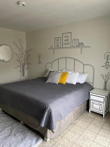 1 dormitorio con cama con colcha gris y almohadas amarillas en Casa Cariño •Room 2•, en Ciudad Guzmán