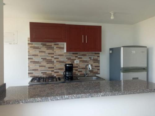 a kitchen with a stove and a refrigerator at Cómodo apartamento cerca al mar in Coveñas