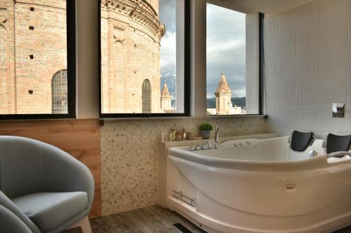 a bathroom with a tub with a view of a building at Hotel Vaway in Cuenca