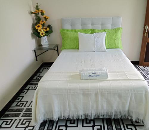 Hotel Alto Amazonas في ليتيسيا: غرفة نوم بسرير ابيض عليها صندوق