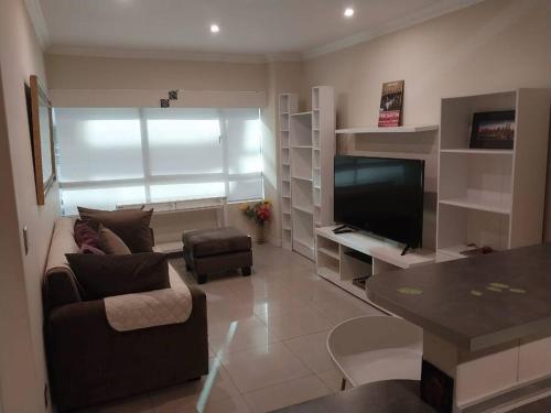 sala de estar con sofá y TV en Suite 211, en Quito