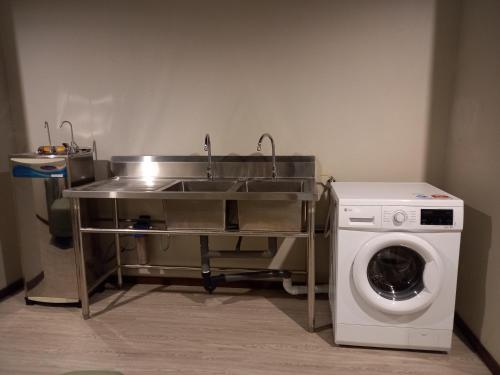 a kitchen with a sink and a washing machine at KAN JIA in Miri