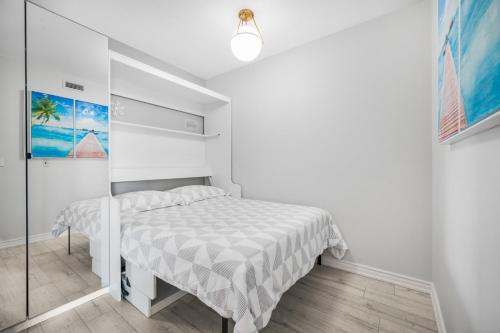 a white bedroom with a bed and a glass wall at Luxury Downtown Toronto 2 Bedroom Suite with City and Lake Views and Free Parking in Toronto