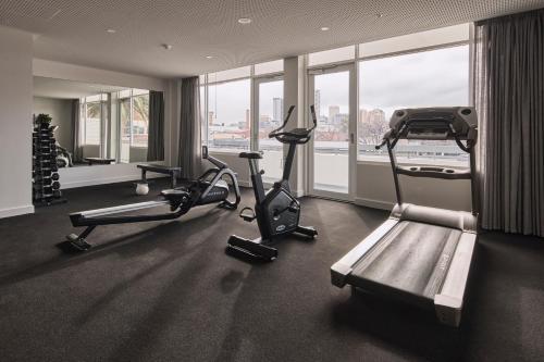 a gym with two exercise bikes in a room with a window at Hotel Alba Adelaide in Adelaide