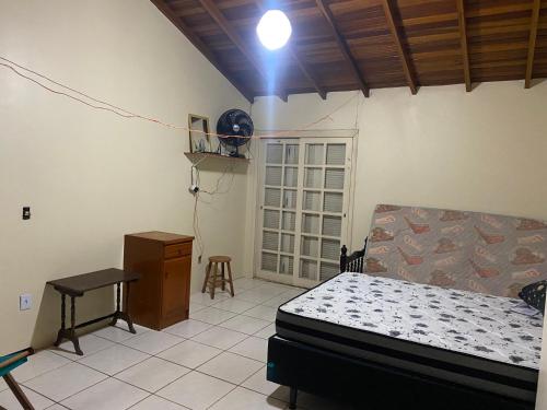een slaapkamer met een bed, een tafel en een bureau bij Apartamento Dúplex in Cidreira