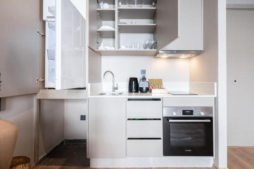 a kitchen with white cabinets and a black oven at TWENTY SIX ANFA LUXURY RESIDENCE by Shortstaymaroc -Hyper Centre -Parking in Casablanca