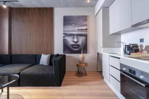 a living room with a black couch and a kitchen at TWENTY SIX ANFA LUXURY RESIDENCE by Shortstaymaroc -Hyper Centre -Parking in Casablanca