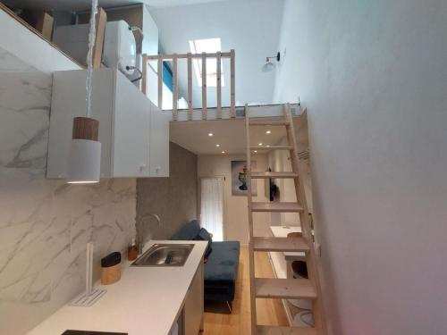 a small kitchen with a staircase leading up to a loft at L'EDEN in Étampes