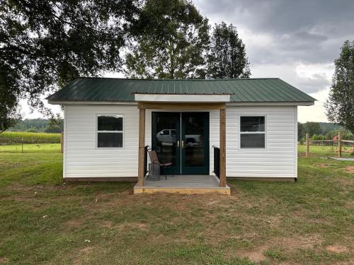 a small white shed with a green roof at Tiny House in Statesville