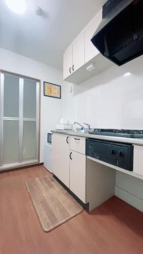 a kitchen with white cabinets and a stove top oven at Happy house -405 in Takamatsu