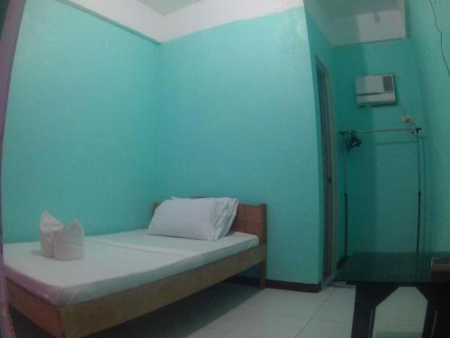 a room with a bed with a blue wall at Lang2 place in San Nicolas