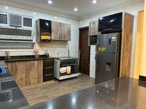 a kitchen with a stainless steel refrigerator and cabinets at Two million hotel 3 in 6th Of October